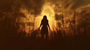 Silhouette of a women in a field with a golden haze behind her